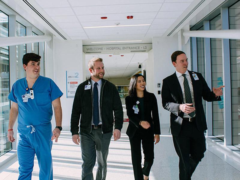 Four MHA students walking through a hospital corridor. Photo by Katherine Socha.