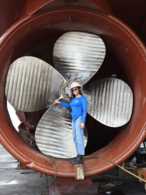 Isabelle Smith dwarfed by the ship's propeller 