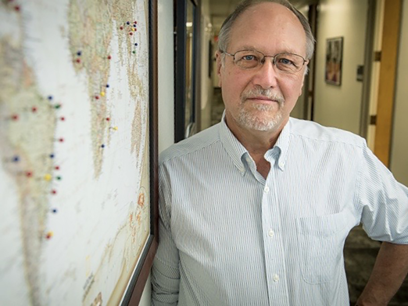 Richard Oberhelman standing next to a wall map
