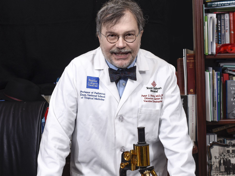 Peter Hotez, wearing lab coat, smiling at camera