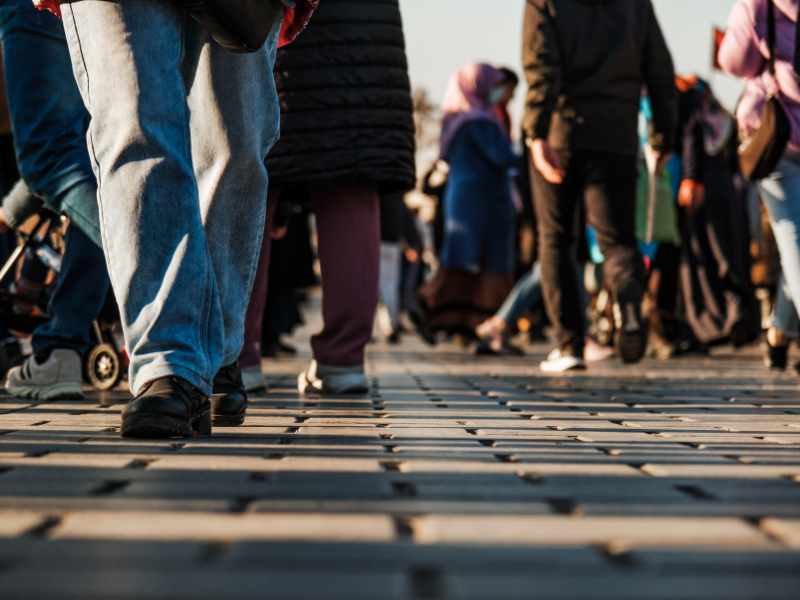 People navigate a crowd on a busy sidewalk