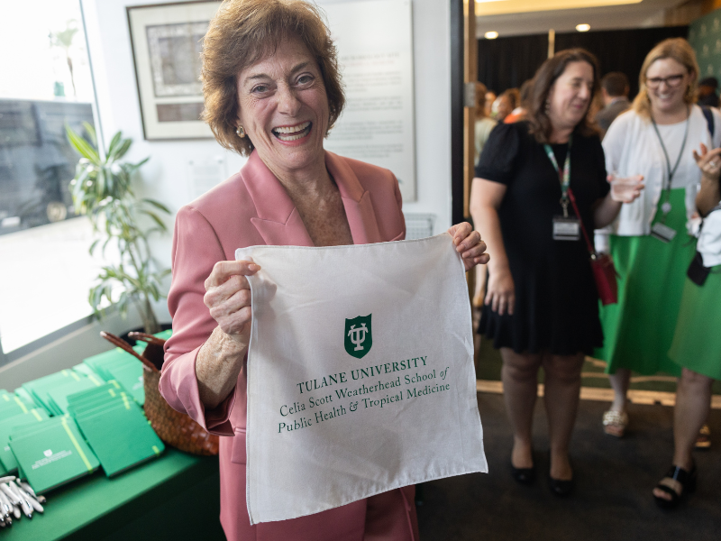 Celia Scott Weatherhead holding up an item displaying the new school name