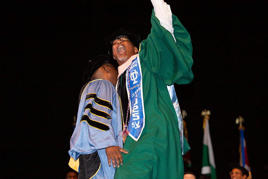 A doctoral graduate giving a triumphant fist bump to the sky