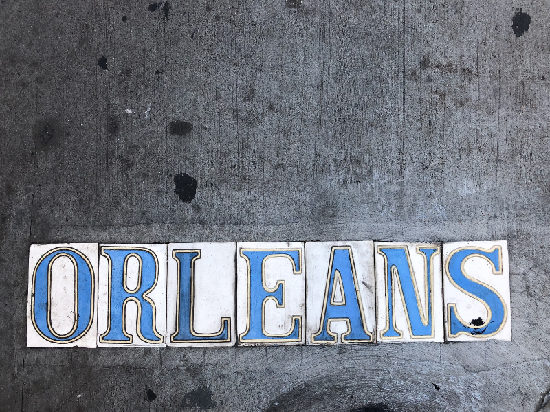 A look at the classic street tiles spelling out a street name, this one of "Orleans"