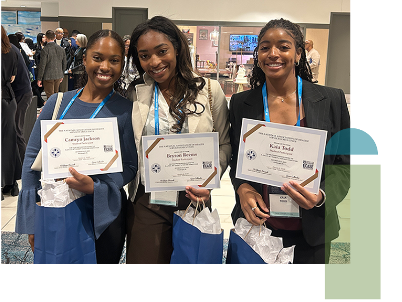 Three WSPH students smiling and holding certificates and blue gift bags at an indoor event.