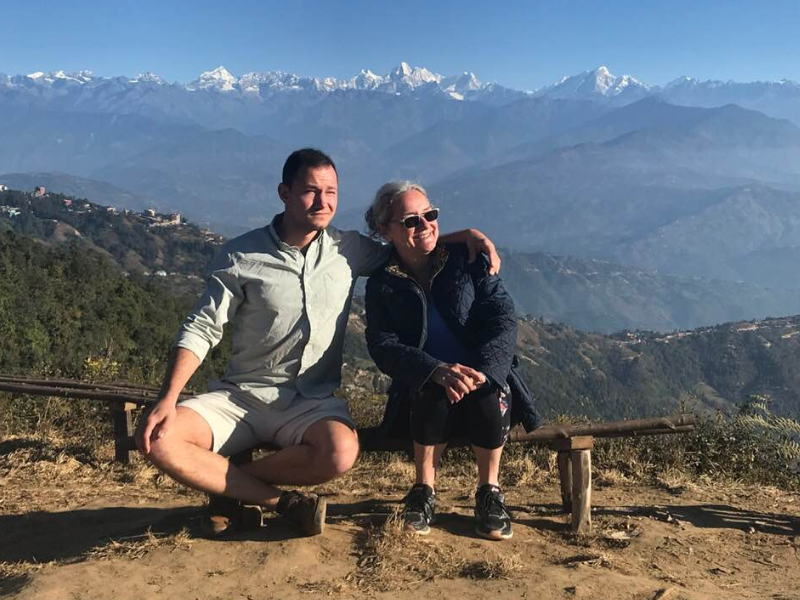 Dr. Nancy Mock with son in front of a mountain range in Nepal