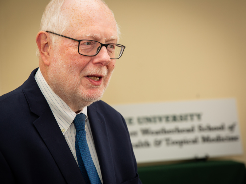 Pierre Buekens speaks, university sign in background.