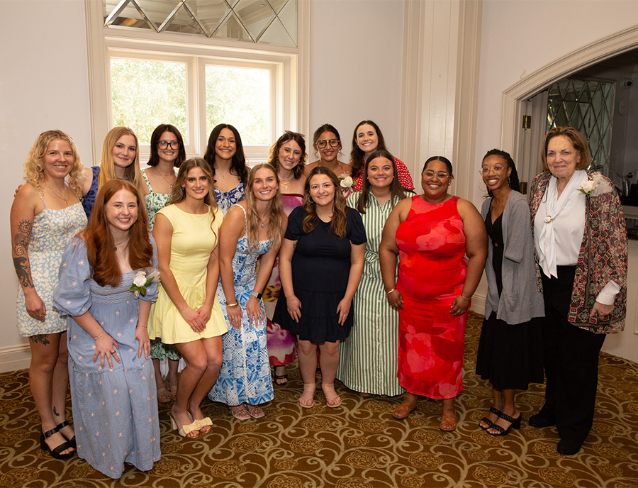 Smiling diverse group of dietetic internship graduates gathered for a group photo at their graduation celebration