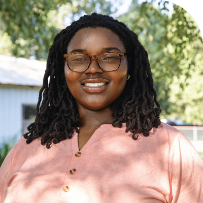 young black lady wearing glasses and a pink shirt