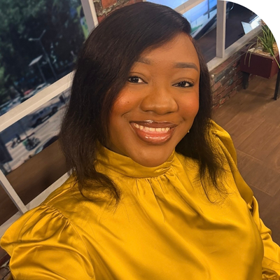 black young lady smiling in mustard colored blouse
