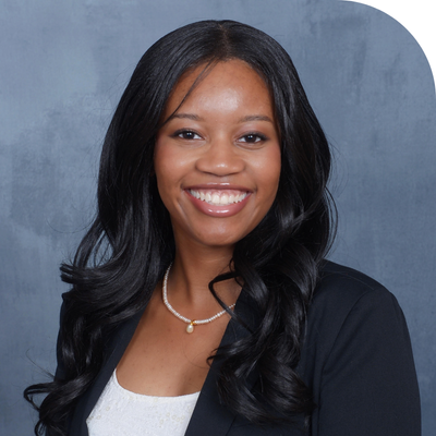 black young lady smiling with black wavy long wig in black suit jacket and white inner top