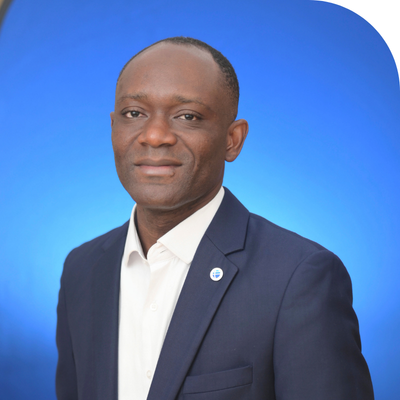 Professional photograph: Man in dark suit, white shirt, against a blue background.