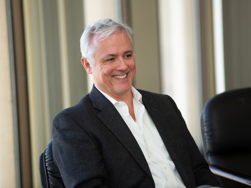 Smiling Stephen Murphy with white shirt, and dark jacket.
