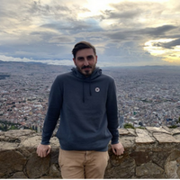 Samuel DiChiara, standing at high altitude, village in background