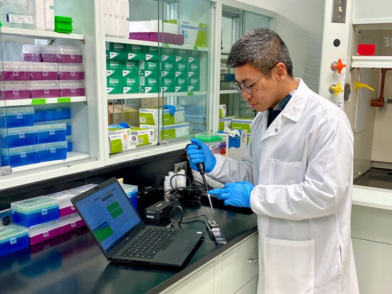 TIong Aw in a lab working with lab equipment