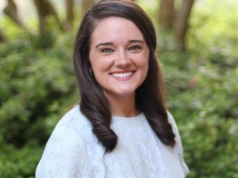 Alexa Dow, headshot, in front of greenery