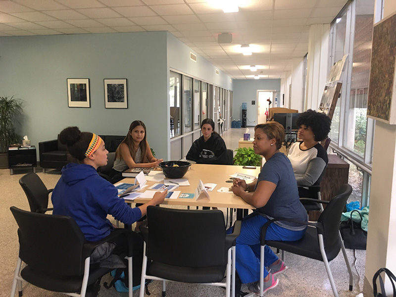 Group of undergraduate public health students talk with alumnnae about life after their degrees. 