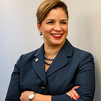 Terri Ricks, blue suit, smiling, arms crossed