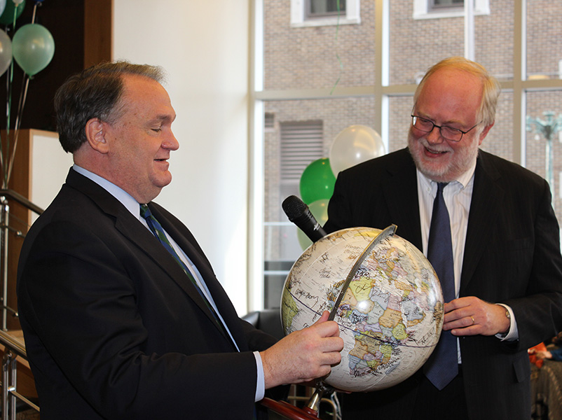 Tulane President Mike Fitts, School of Public Health Dean Pierre Buekens look at a globe signed by students, faculty, and staff