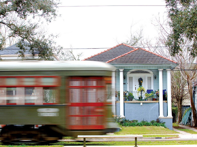 St. Charles Avenue Green line streetcar passing a blue house