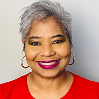 Shannon B. Joseph, smiling, wearing red top, headshot