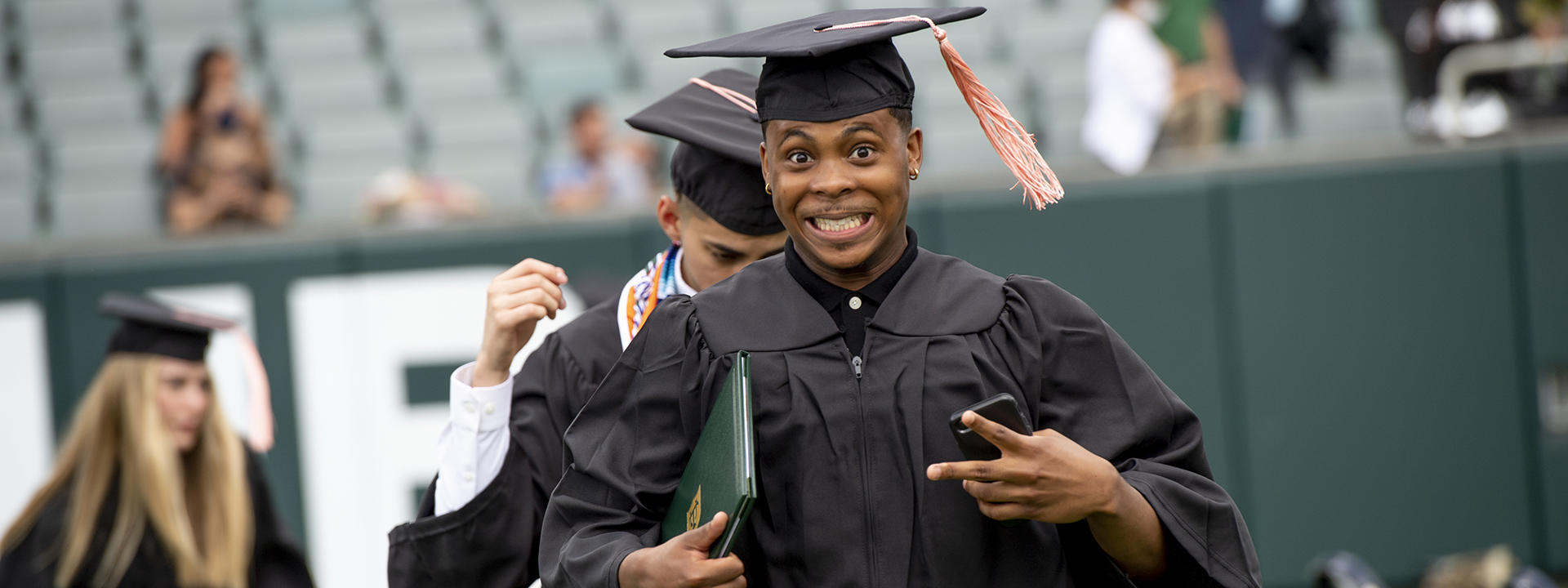 SPHTM Graduate Throwing Peace Sign and Smiling