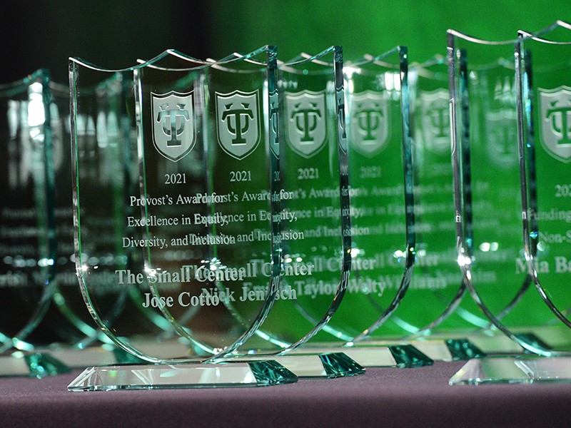 Photo of glass awards against a green wall