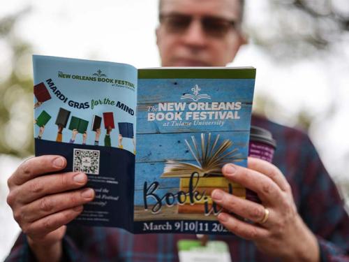 Person reading a Book Fest brochure