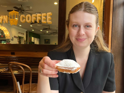 Student Ambassador: Madeline Walaszek Madeline Walaszek holding a beignet, smiling