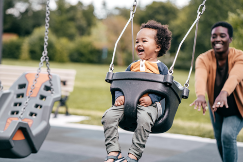 Strategic Initiatives | Celia Scott Weatherhead School of Public Health Small child on a swing being pushed by mom