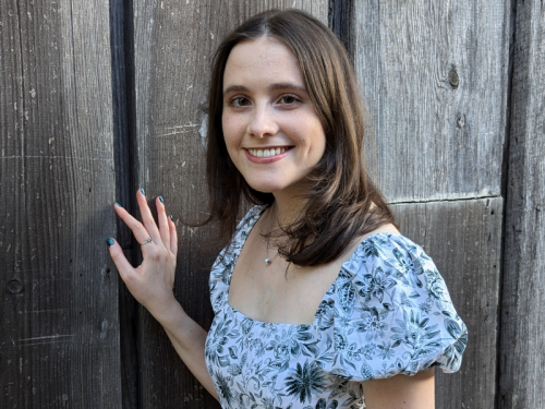 Student Ambassador Alexandra Mack | Celia Scott Weatherhead School of Public Health and Tropical Medicine Alexandra Mack smiling, hand on a wooden fence