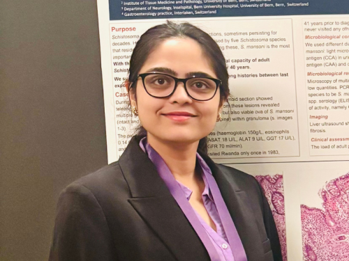 Student Ambassador Preethi Vennela Royuru| Celia Scott Weatherhead School of Public Health and Tropical Medicine Preethi_Vennela_Royuru wearing glasses, looking into camera, standing in front of a poster presentation