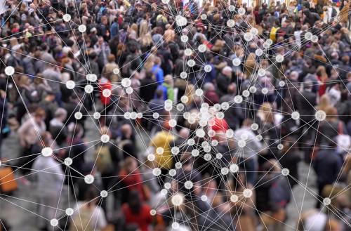 Photograph of a dense crowd with a white digital network graphic overlay.