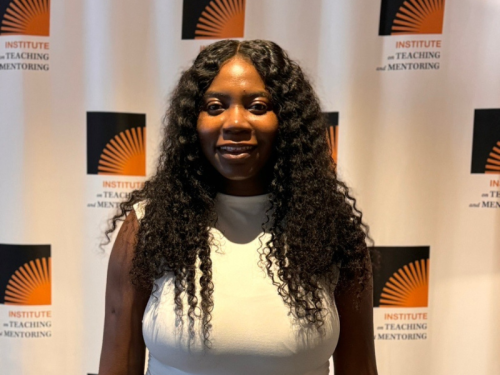 Inngide Osirus smiling in front of a logo wall.