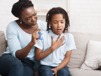 A child struggling with asthma in front of mother