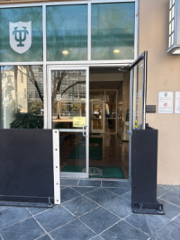 Glass entrance door to the Tidewater building at Tulane University logo above.