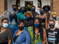 Carolyn Barber Pierre, front, center, surrounded by colleagues at ribbon cutting for her intercultural life center