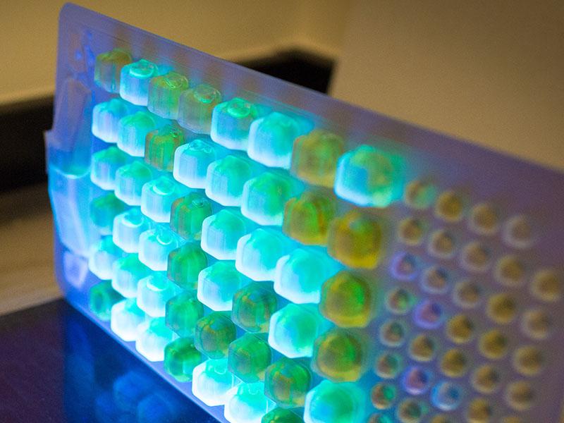 Close up image of blue, green lights on some lab equipment Close up image of blue, green lights on some lab equipment