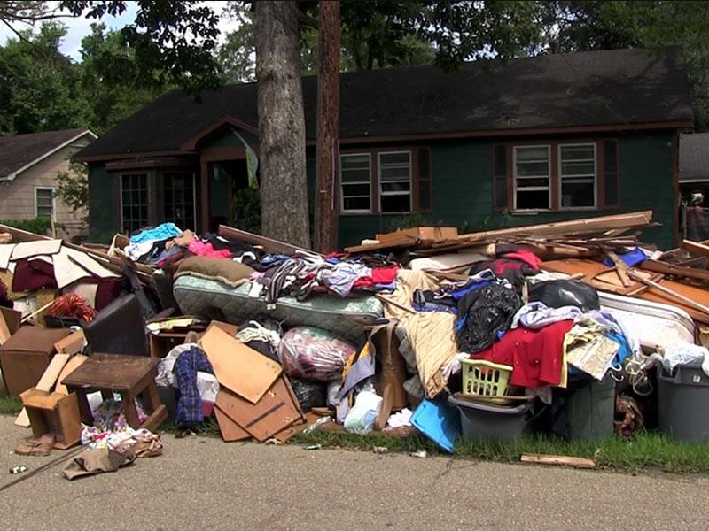 Piles of debris - clothes, furniture, etc. - outside of homes that flooded in Baton Rouge, LA in 2014. Photo by Carolyn Scofield.