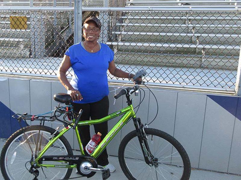 Movin' for Life Photovoice Project participant Cynthia Atkins stands with her bike at a park near her home