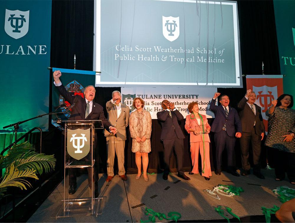 Fitts raises his arm in the air as dignitaries pose for photos.