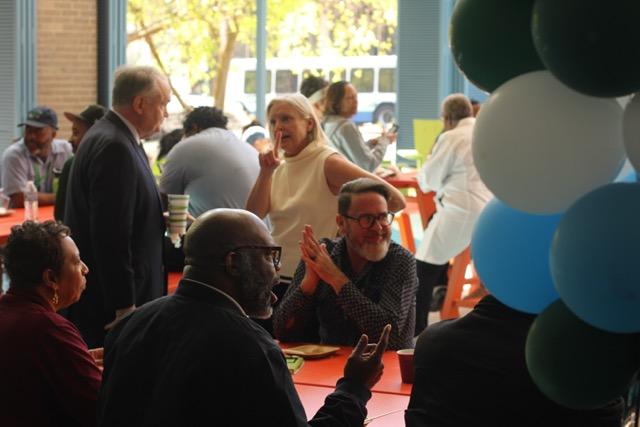 Balloons in foreground, people eating in background at Wave City Market