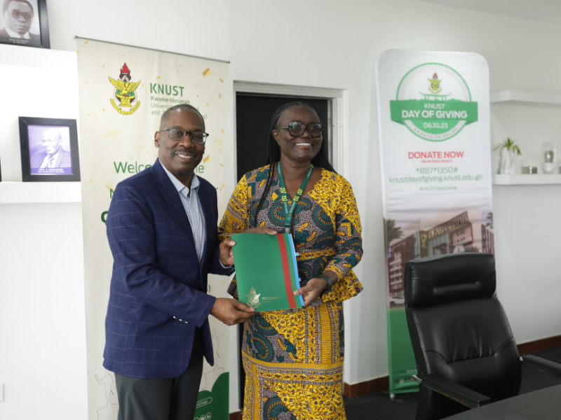 Dean LaVeist shaking hands over signed documents at KNUST