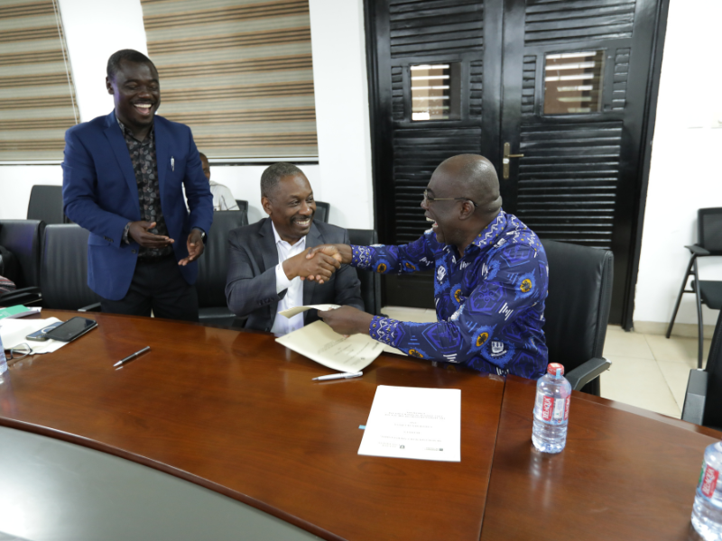Dean LaVeist shaking hands over signed documents at U Ghana