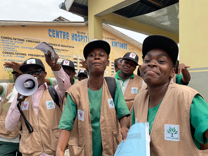 Three volunteers are shown collecting data for a survey in Africa.