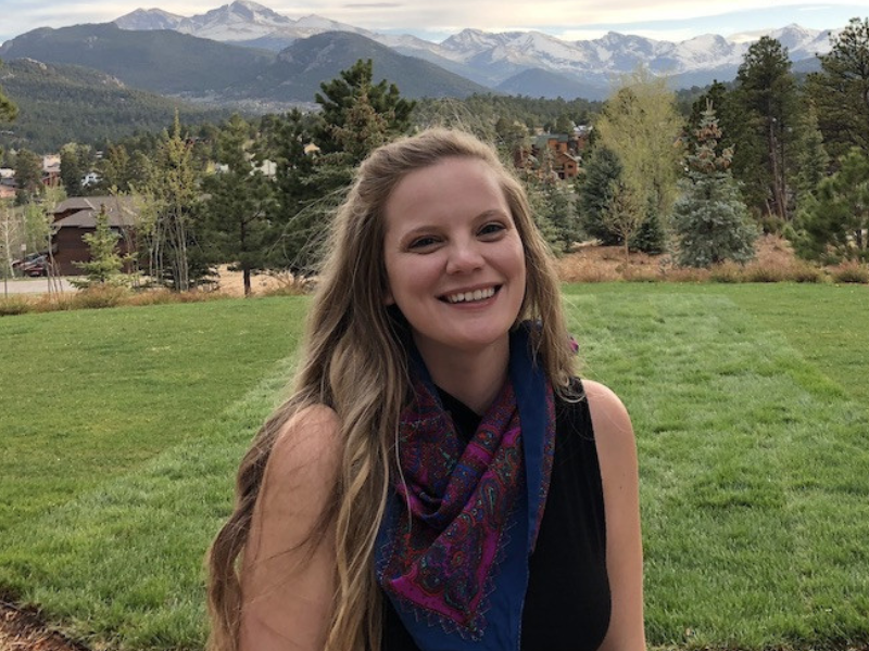 Angela Philpot adorned in scarf, mountains in background.