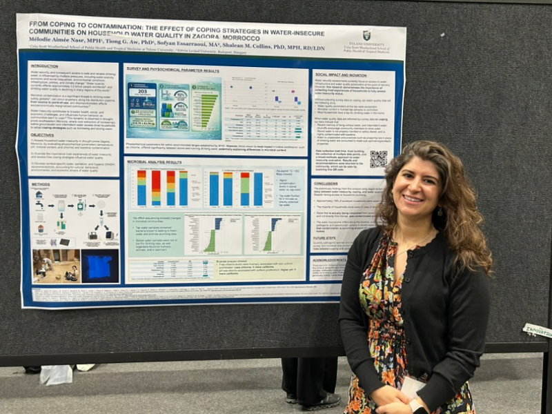 Mélodie Nasr posing in front of her poster
