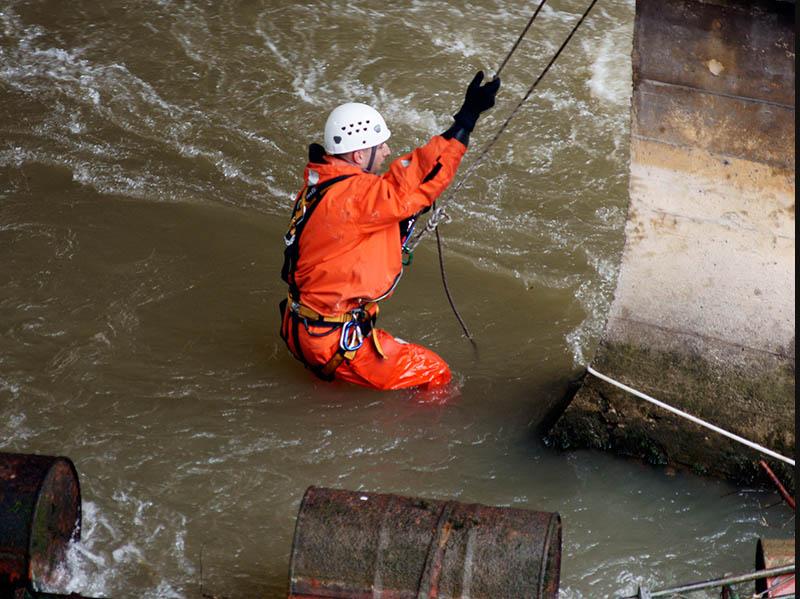 Rescue worker lowering into flood waters Rescue worker lowering into flood waters