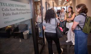 People gather in a hallway outside Tulane University's School of Public Health.
