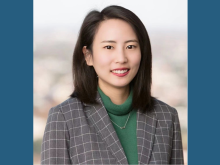 PhD Candidate Yixue Shao smiling at camera, plaid suit